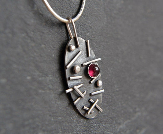 Garnet oxidised sterling silver oval necklace.