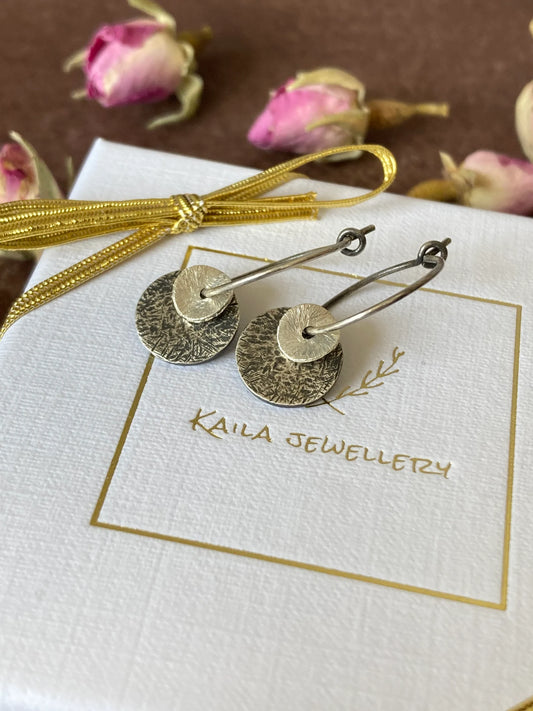 Sterling silver oxidised hammered disc hoop earrings.